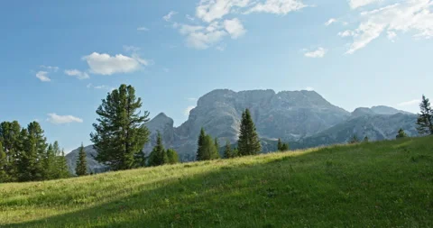 Sunlit alpine meadow with Dolomites mountains in summer Stock Footage 340792346