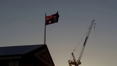 Sunlit Australian Flag with crane in 4k Stock Footage 104599269