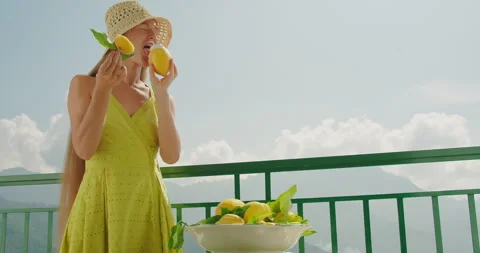Sunlit balcony setting with a lady in a hat tasting fresh lemon sorbet or ice Stock Footage 274563723
