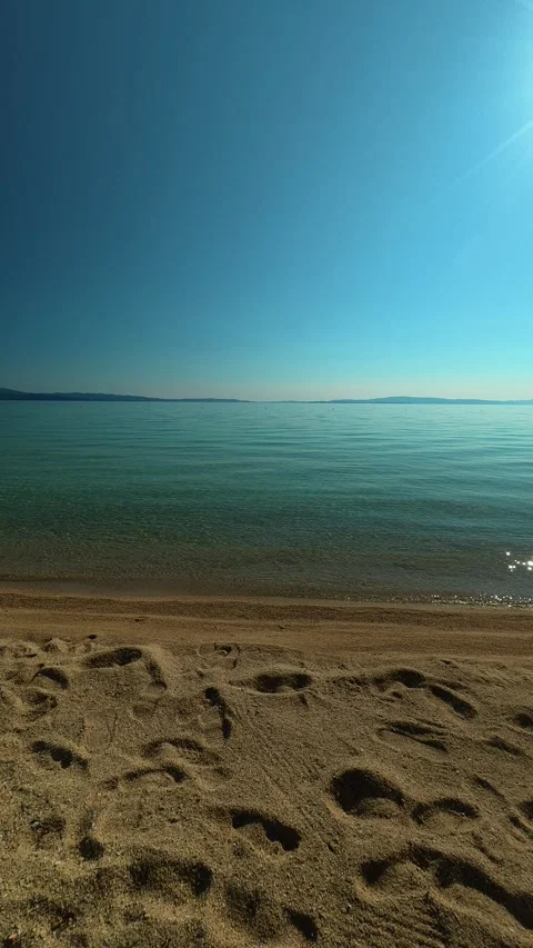Sunlit beach with clear water and quiet calm. Trani Ammouda, Greece. Vertical Stock Footage 339629050