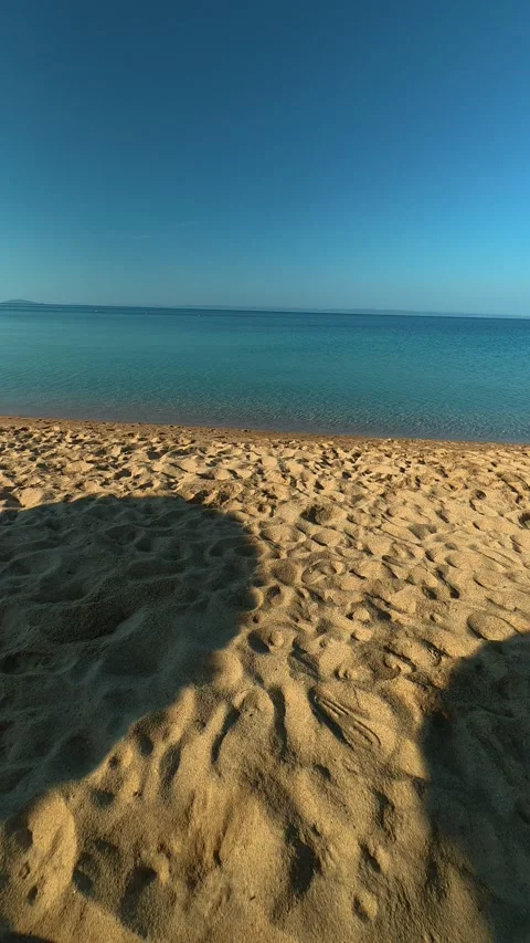 Sunlit beach with soft sand and calm sea. Nikiti, Greece. Vertical Vídeo Stock 338357549