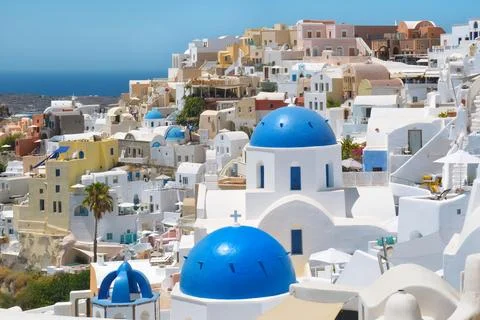 Sunlit Blue Domes and White Houses of Oia Santorini Overlooking the Aegean Se Stock Photos