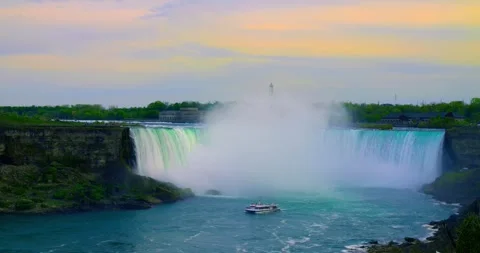 Sunlit cascade edges at Niagara Falls, mist plume drifting across falls and Stock Footage 312579905