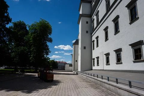Sunlit castle facade and tree lined square in Vilnius, Lithuania with clear.. Stock Photos