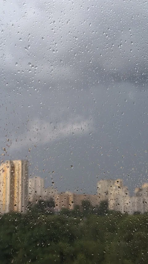 Sunlit Cityscape through Rainy Window with Raindrops Vertical Video.. Video stock 318071611