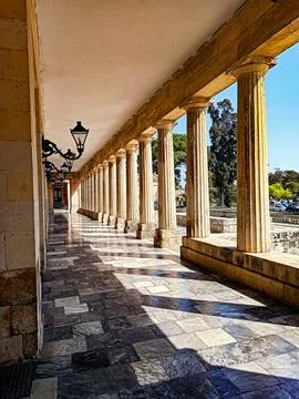 Sunlit classical colonnade with marble floor Stock Photos