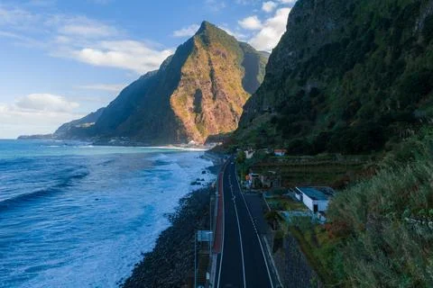 Sunlit cliffs and coastal road on Madeira near Seixal and Sao Vicente Stockfoto's