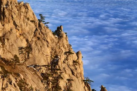 Sunlit cliffs and sea in clouds at evening Foto stock