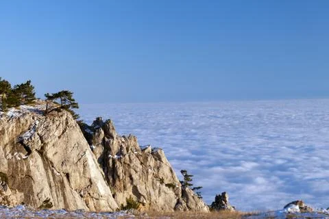 Sunlit cliffs and sea in clouds Stock Photos