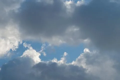 Sunlit cloud break with glowing edges, rays peeking through dark formations,  Stock Photos