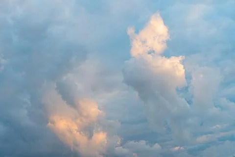 Sunlit cloudscape with varying textures, dynamic movement, contrasting light  Stock Photos