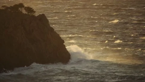 Sunlit coastal headland over rough ocean Video stock 168777034