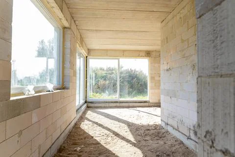 Sunlit corner of a room in an under-construction house with exposed concret.. Stock Photos