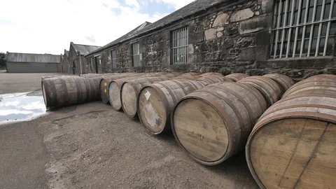 Sunlit External Slider Shot of Whiskey Barrels Outside a Scottish Distillery Stock-Footage 97615841