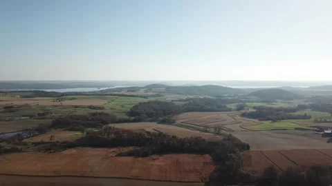 Sunlit farmland patchwork and rolling hills – aerial view 스톡 동영상 311869318