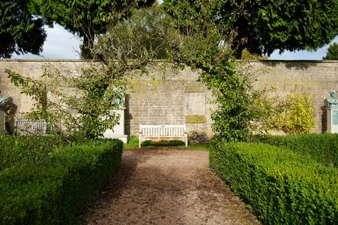 Sunlit Garden Path, White Bench, And Stone Wall At Newstead Abbey, England. Stock Photos