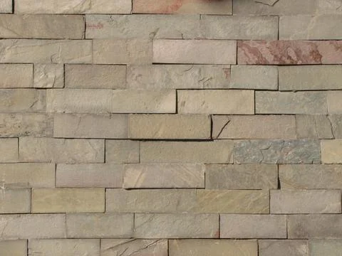 Sunlit geometric rectangular natural gray stones wall background. 写真素材