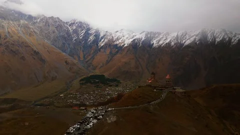 Sunlit Gergeti Trinity Church perched high in the Caucasus Mountains Stock Footage 320254488