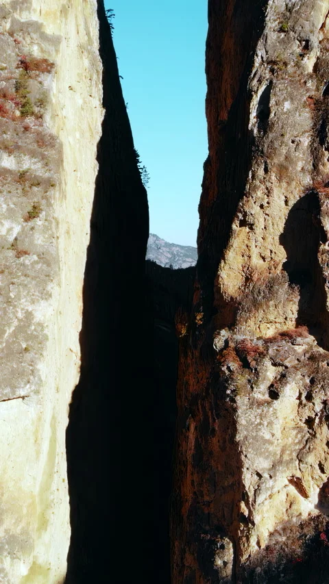 Sunlit Gorge With Rugged Basalt Walls. Remote Rocky Chasm With Contrasting Stock Footage 346049842