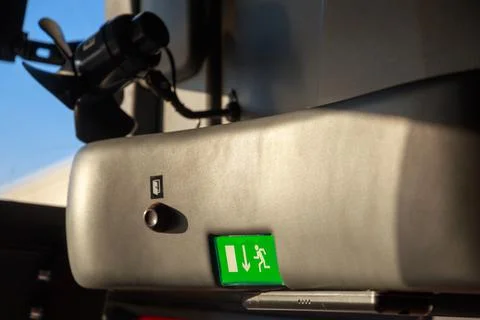 Sunlit green emergency escape exit sign above the front door of a tourist Stock Photos