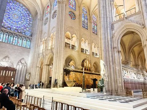 Sunlit interior view of Notre Dame cathedral in Paris France showing rose w.. Stock Photos