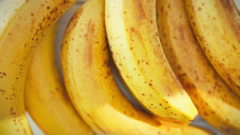 On sunlit kitchen table bright banana branch rests its yellow fruit speckled Stock Footage 338187416