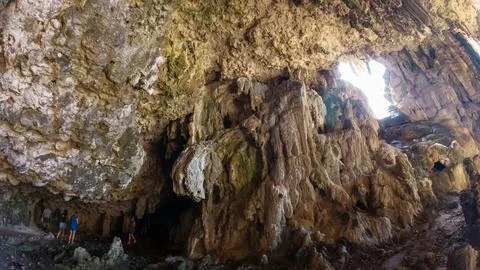 Sunlit limestone cave interior with rock formations Stock Photos