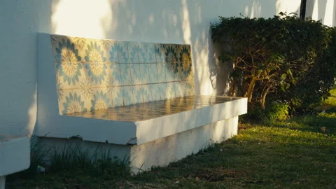 Sunlit Mediterranean Tiled Bench Against White Wall Stock Footage 329459223
