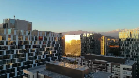 Sunlit Modern Buildings with Mountain Backdrop at Dawn Stock Footage 296922717