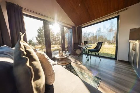 Sunlit modern cabin interior with A frame ceiling and glass walls Stock Photos