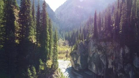  Sunlit mountain gorge and river valley near Lake Kaindy, Kazakhstan Stock Photos