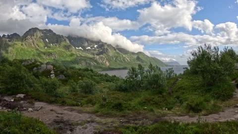 Sunlit mountain hiking path overlooking scenic fjord and peaks in Norway Vidéo 343833621