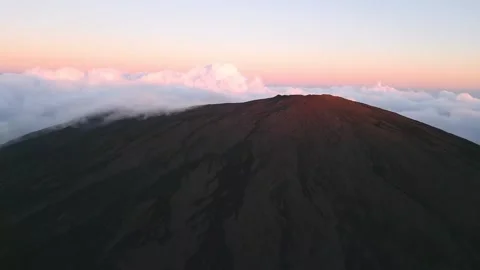 Sunlit Mountain Peak Surrounded by Clouds Stock Footage 315090203