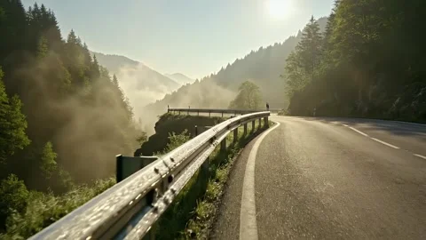 Sunlit Mountain Road Winding Through Foggy Valley Forest Landscape Video stock 330109042