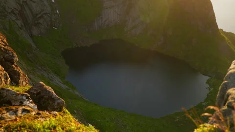 Sunlit Mountain Tarn Below Sheer Rock Walls in Norway Lofoten Stockbeeldmateriaal 340013366