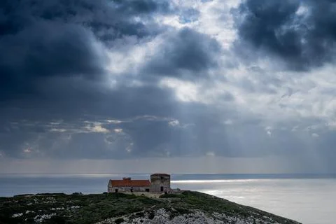 Sunlit ocean beneath storm clouds at Cabo Espichel lookout Stock Photos