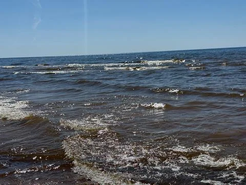 Sunlit Ocean Waves Under Clear Blue Sky Background Photos