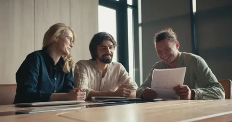 Sunlit Office Connections: Dynamic Conversations and Joyful Laughter with the Stock Footage 242899351