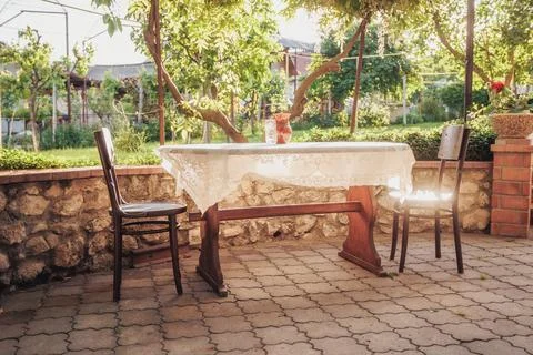 Sunlit Outdoor Table Set For Two With Linen Tablecloth And Mismatched Chairs, Stock-Fotos
