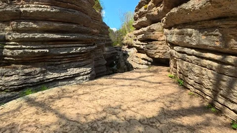 Sunlit path winds between towering rock faces. Rosomac Canyon, Serbia Stock Footage 335535339