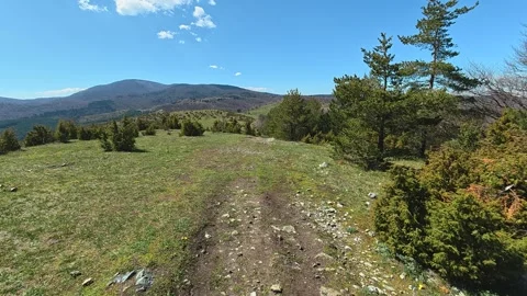 Sunlit path winds through green hills. Balkan, Eastern Europe, POV Video stock 333442449