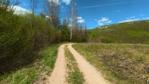 Sunlit path winds through green hills. Balkan, Eastern Europe, POV Vídeo Stock 333589769