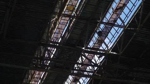 Sunlit Patterns on Industrial Roof Structure with Open Sky Stock Footage 337635140