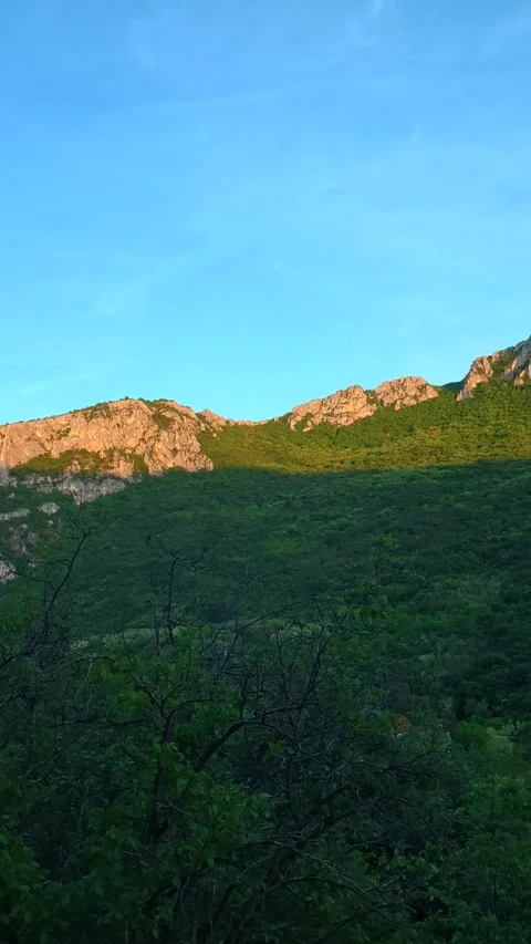 Sunlit peaks rise above deep green valleys. Sicevo Gorge, Serbia. Vertical Видео 337057842