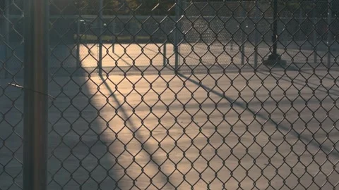 Sunlit Pickleball Court Viewed Through Chain Link Fence Stock Footage 337410330