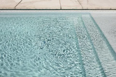 Sunlit Pool Steps with Clear Rippling Water Stock Photos