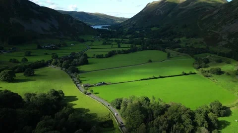 Sunlit pools moving across lush green patchwork fields on valley floor Stock-Footage 249131267