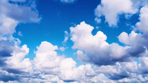 Sunlit puffy clouds moving across a vibrant blue sky timelapse Stock Footage 332726829