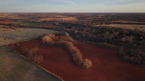 Sunlit Red Plowed Field With Tree Line Divider Oklahoma Farmland Aerial Stock Footage 329192347