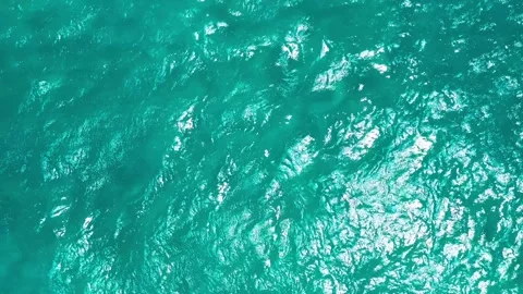 Sunlit Ripples on Vibrant Teal Ocean Surface 库存影片 334016209